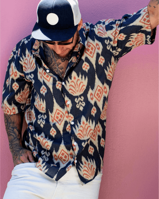 PADMA Short Sleeve Shirt Blue Ikat worn by a man against a colorful background, showcasing its stylish design — The Cocoon Way
