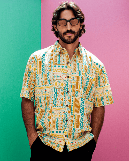 Model wearing the PADMA Short Sleeve Shirt, featuring a vibrant yellow tribe pattern, perfect for stylish casual wear.