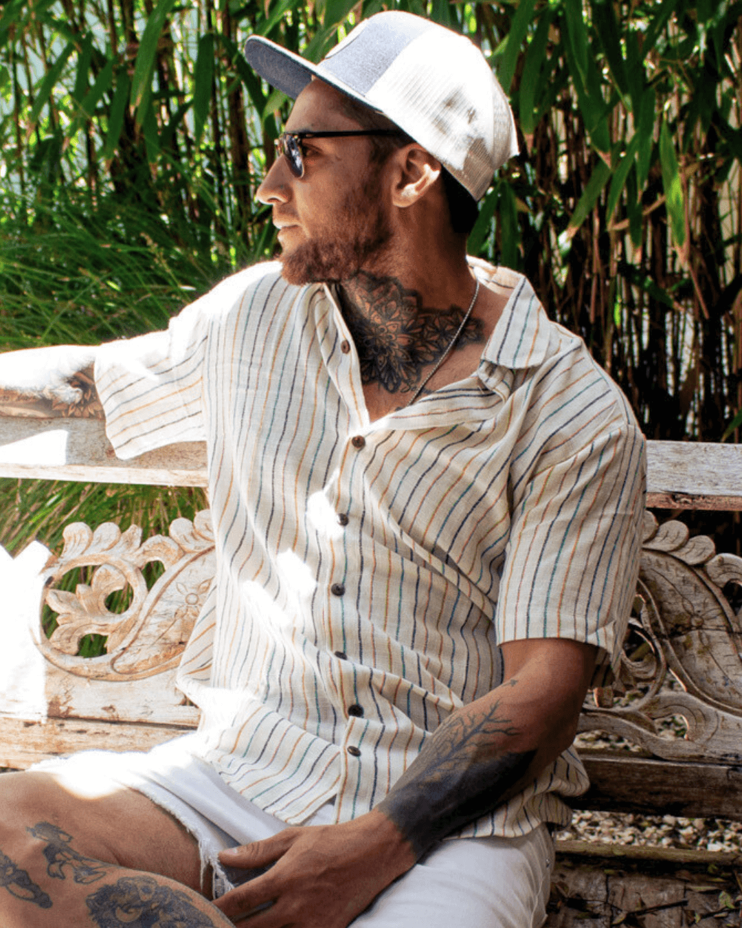 A man wearing an AMBE Short Sleeve Shirt in a tropical setting, exuding casual style and comfort.