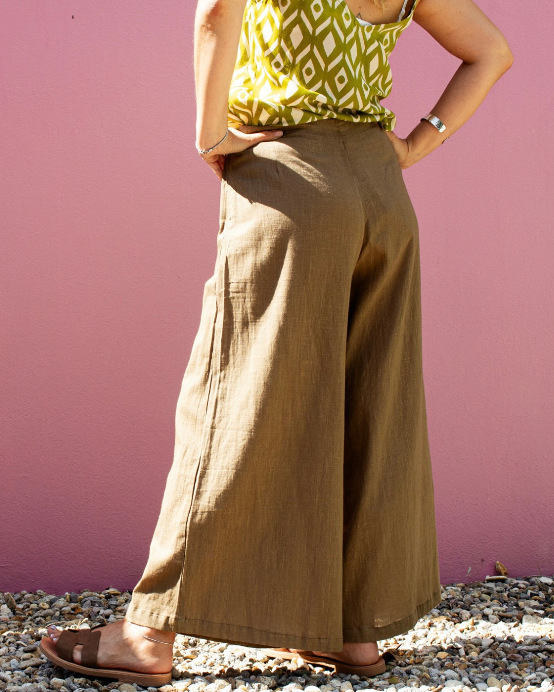 CLODY Cotton Pants in sand color, featuring wide-leg cut and adjustable waist, worn casually against a pink background.