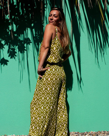 Model wearing OLIVIA Pants in lime ikat print against a vibrant green wall, showcasing the relaxed fit and style.