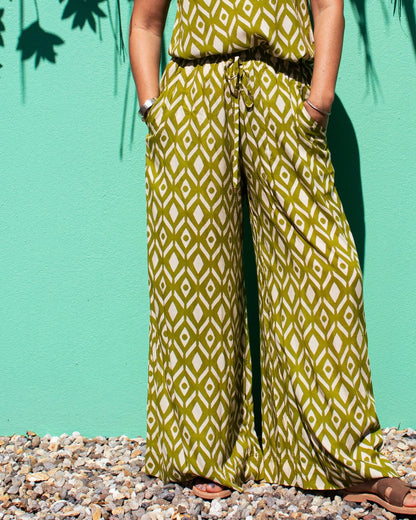 Model wearing OLIVIA Pants in Lime Ikat pattern, showcasing relaxed fit and wide leg design against a colorful backdrop.