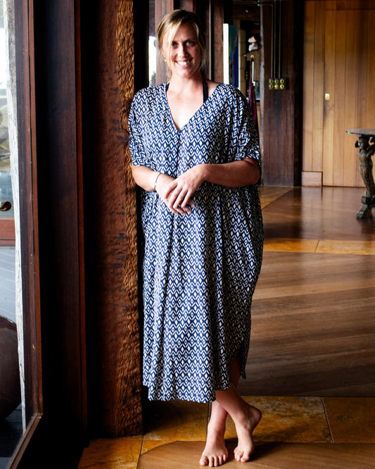 Model wearing GLORIA Dress in Royal Ikat design, showcasing its flowy kaftan silhouette in an elegant indoor setting — The Cocoon Way