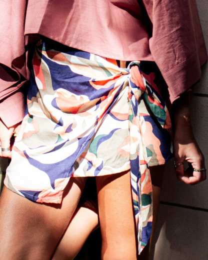 Close-up of a model wearing the VERA Skort featuring a colorful pareo-inspired design and adjustable side knot — The Cocoon Way