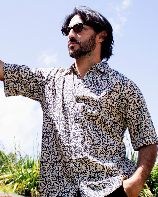 Man wearing a SAIRA Short Sleeve Shirt in Maui Black, showcasing its lightweight and breathable design — The Cocoon Way