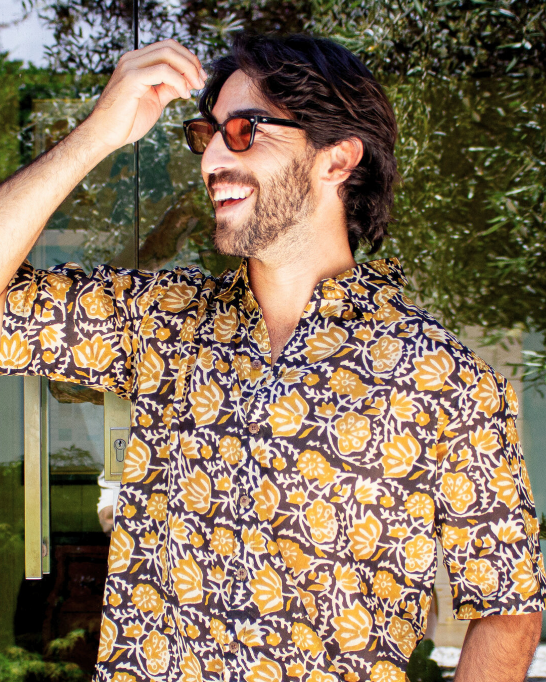 SAIRA Short Sleeve Shirt worn by a smiling man outdoors, showcasing floral design and relaxed fit — The Cocoon Way