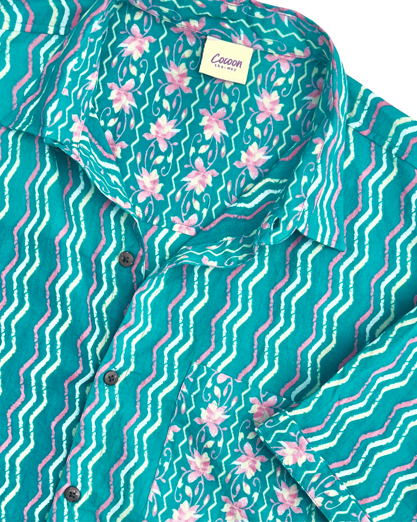 Close-up of the PADMA Short Sleeve Shirt featuring a vibrant Neon Wave pattern and soft Cambric cotton fabric — The Cocoon Way