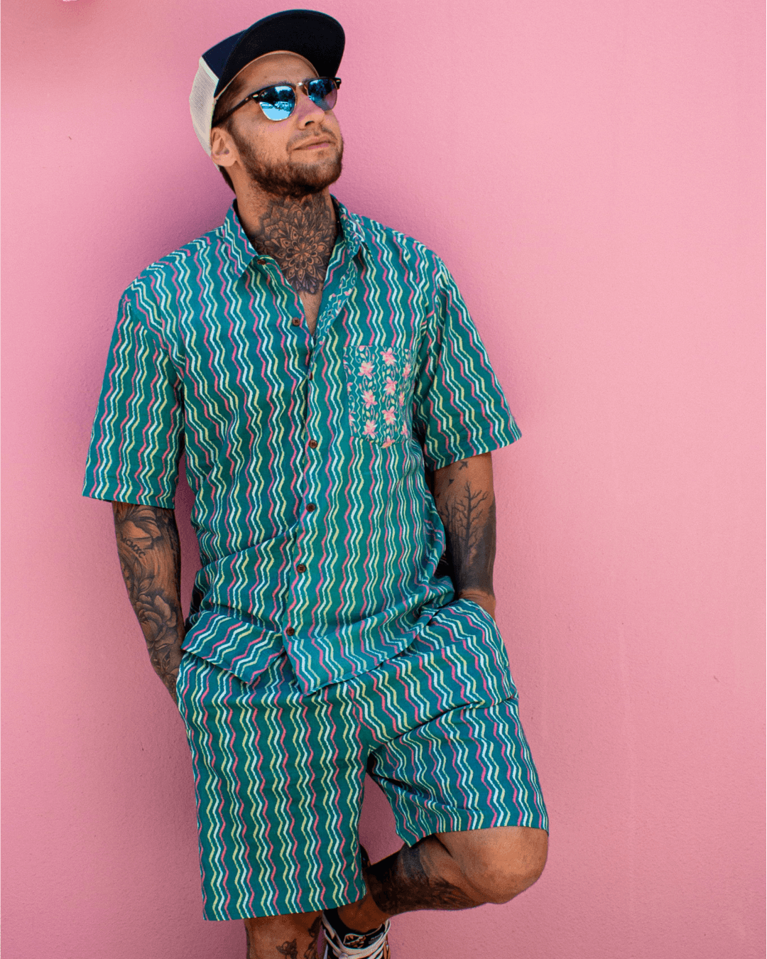 Man wearing PADMA Short Sleeve Shirt Neon Wave with vibrant colors against a pink background — The Cocoon Way