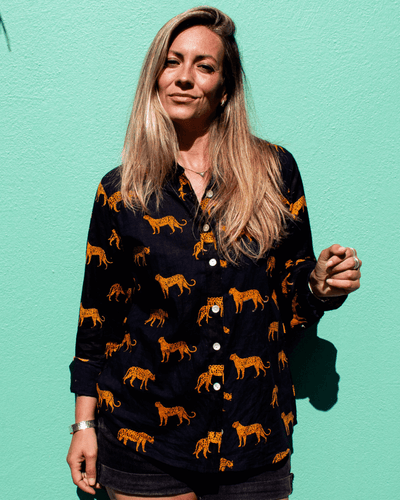 LEOPARD Cotton Shirt modeled by a woman, featuring a vibrant leopard print design against a teal background — The Cocoon Way