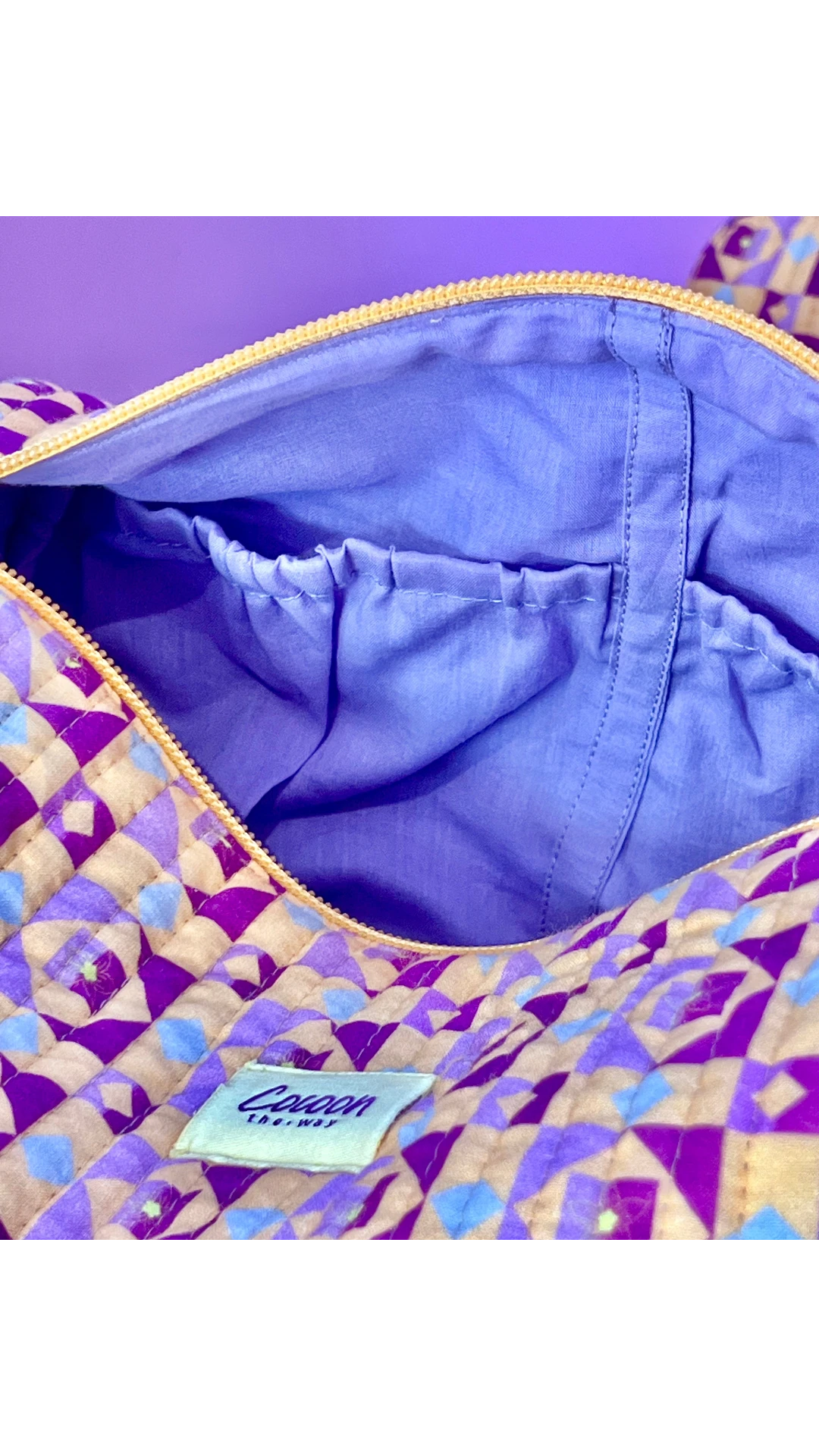 The Cocoon Way Niwas large quilted cotton pouch with purple geometric print, zip closure, and lined interior pocket.