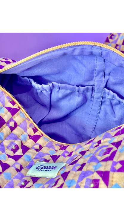 The Cocoon Way Niwas large quilted cotton pouch with purple geometric print, zip closure, and lined interior pocket.