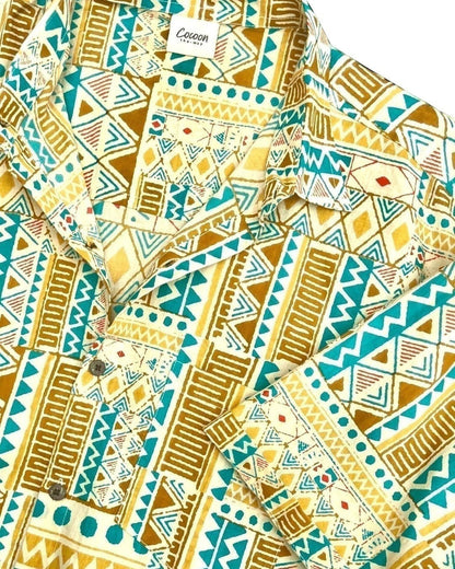 The Cocoon Way PADMA short sleeve shirt in yellow and teal with a geometric tribal print, made from 100% cotton.